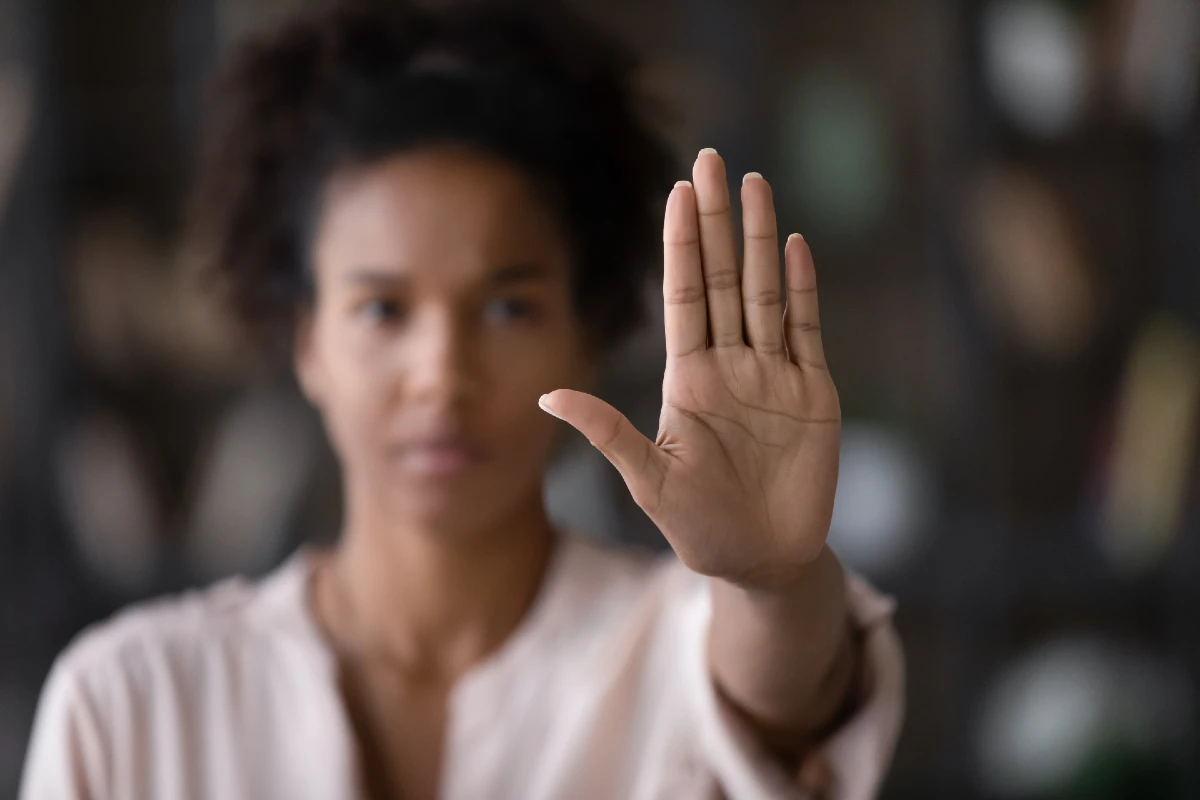 Image of a woman with her hand up signaling stop